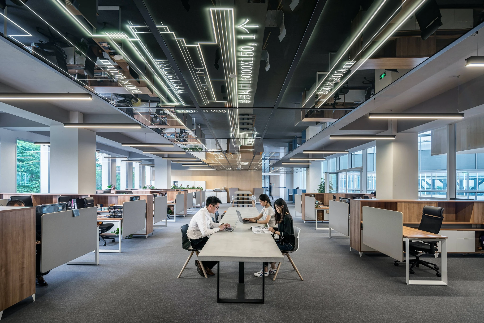 Two people sitting at a desk in an office building.