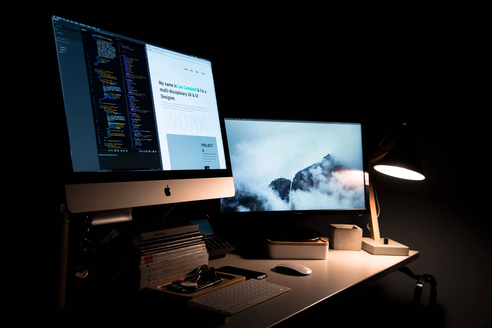 Office desk with two Apple iMacs working on webdesign.